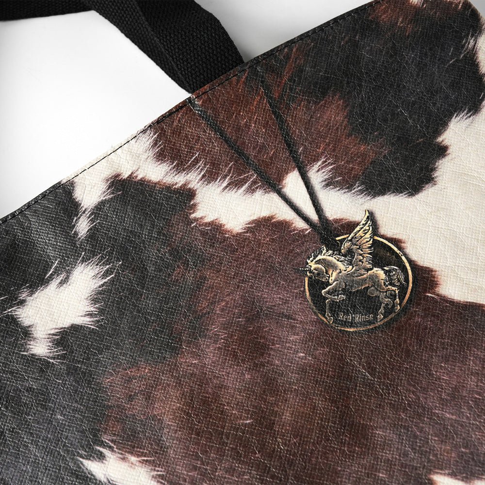 EMBER Tyvek tote bag cow print texture and metal charm detail