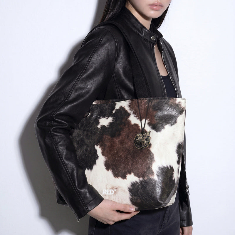 Close styling view of EMBER cow print Tyvek tote bag