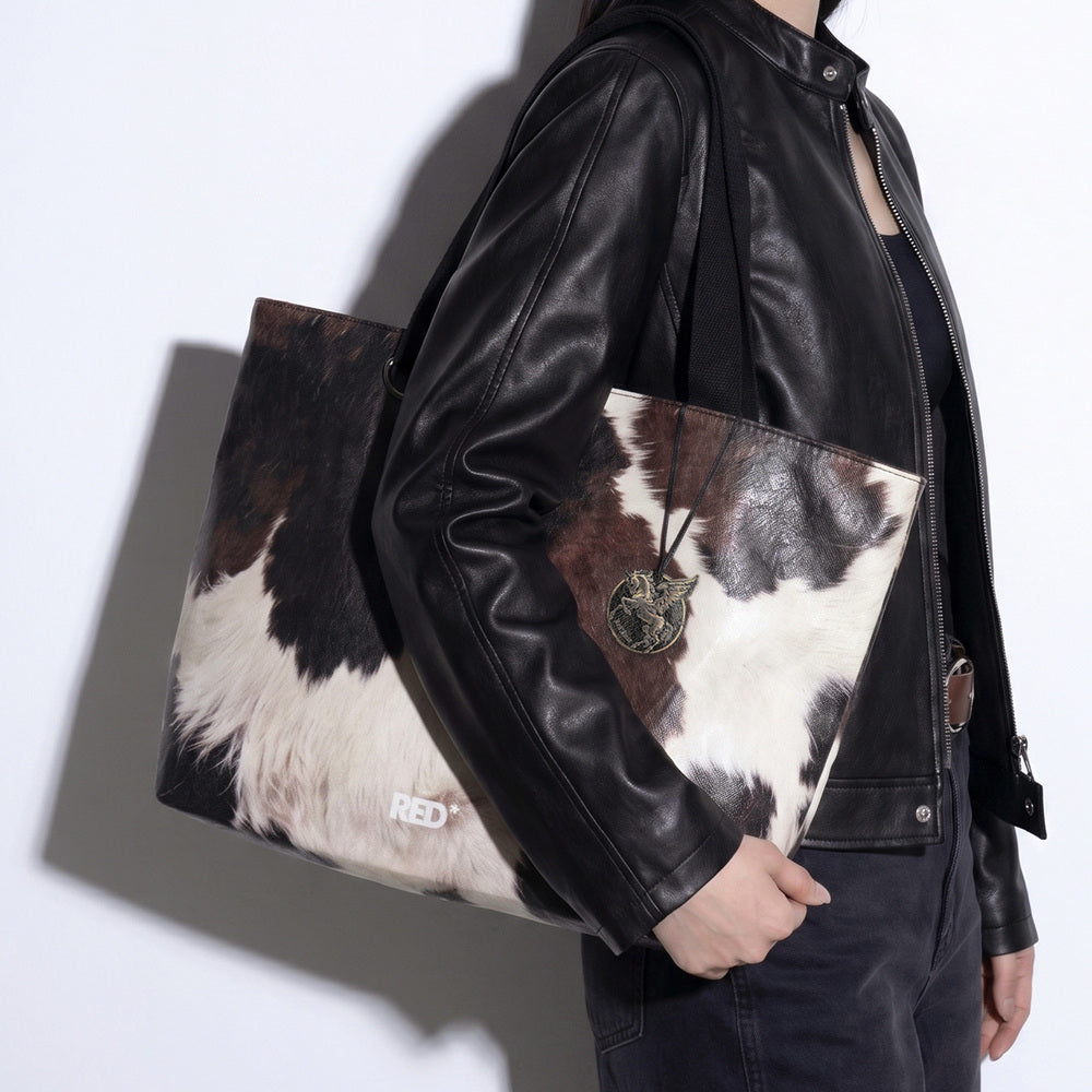 Side styling view of EMBER cow print Tyvek tote bag