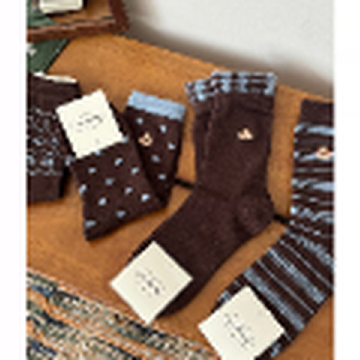 Four blue and brown crew socks arranged in a flat lay