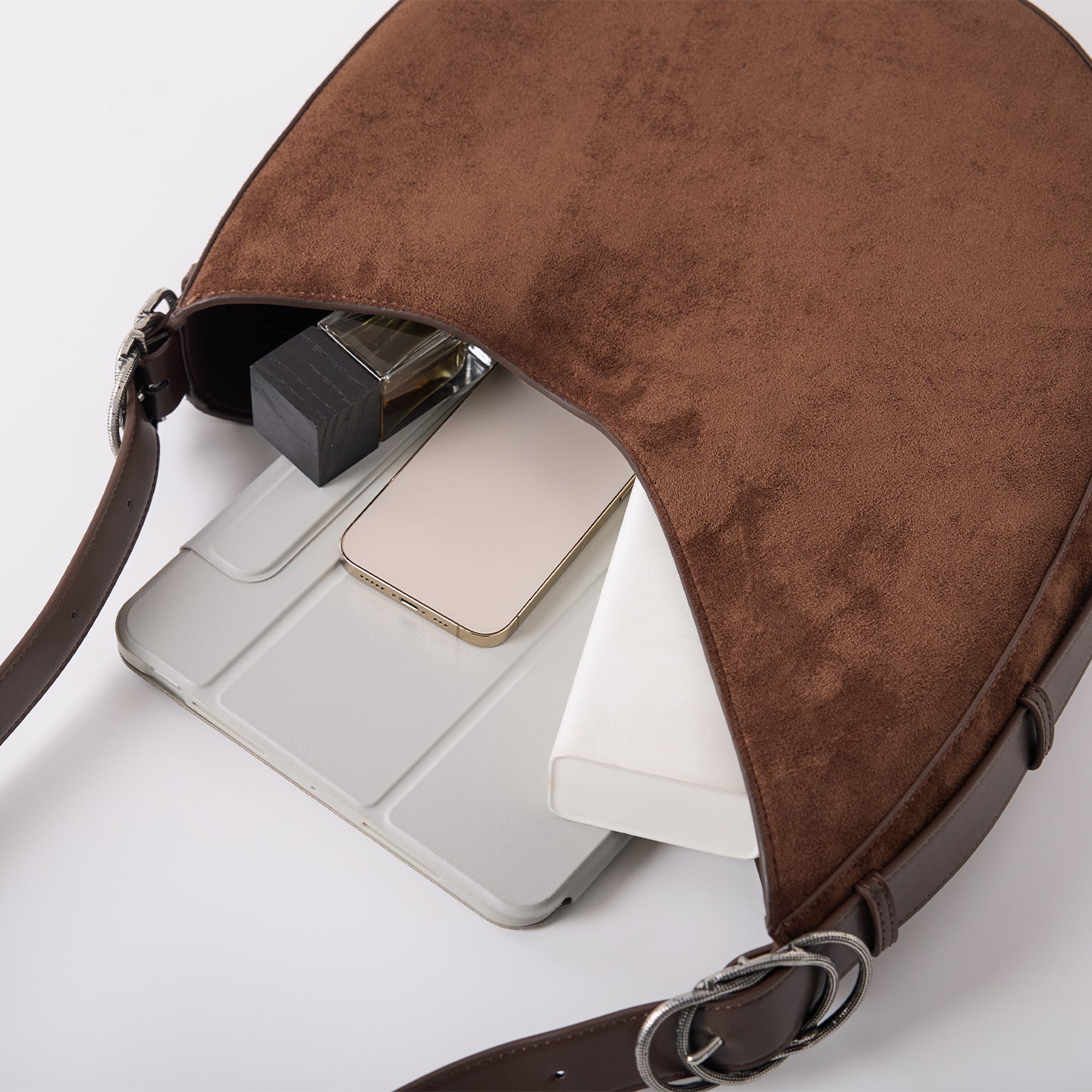 CRESCENT saddle bag capacity shown with tablet and daily essentials