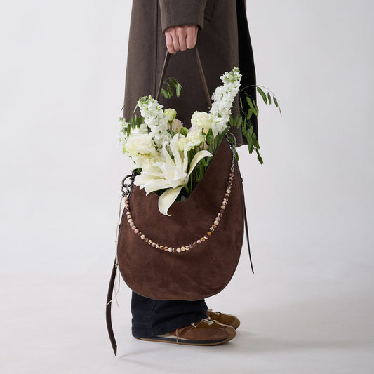 CRESCENT faux suede bag carried by hand with flowers