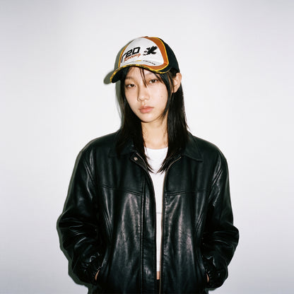 Model wearing HORIZON embroidered racing cap with black leather jacket