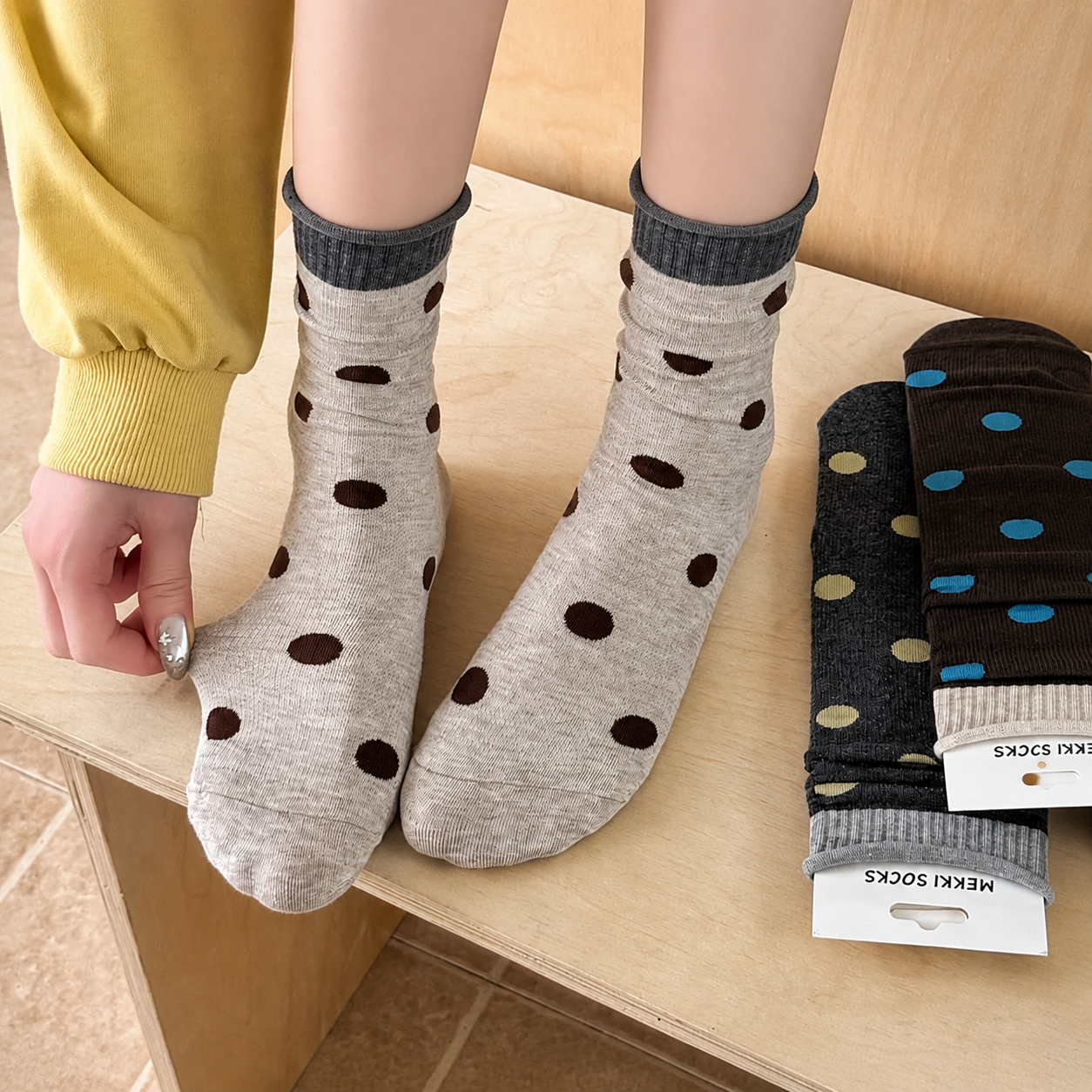 Light-gray polka-dot slouch socks worn with a relaxed rolled cuff